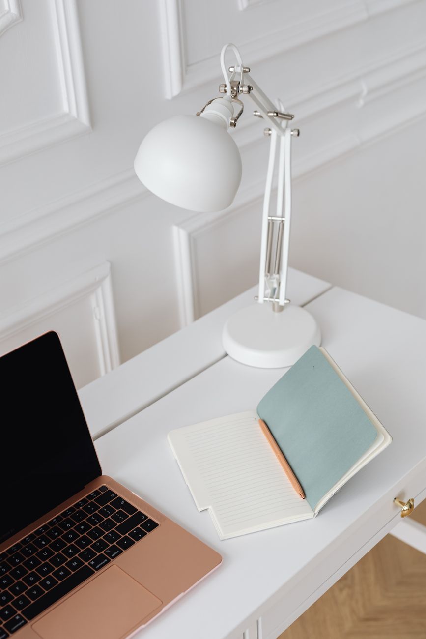 Skrivebord med lampe og notesbog